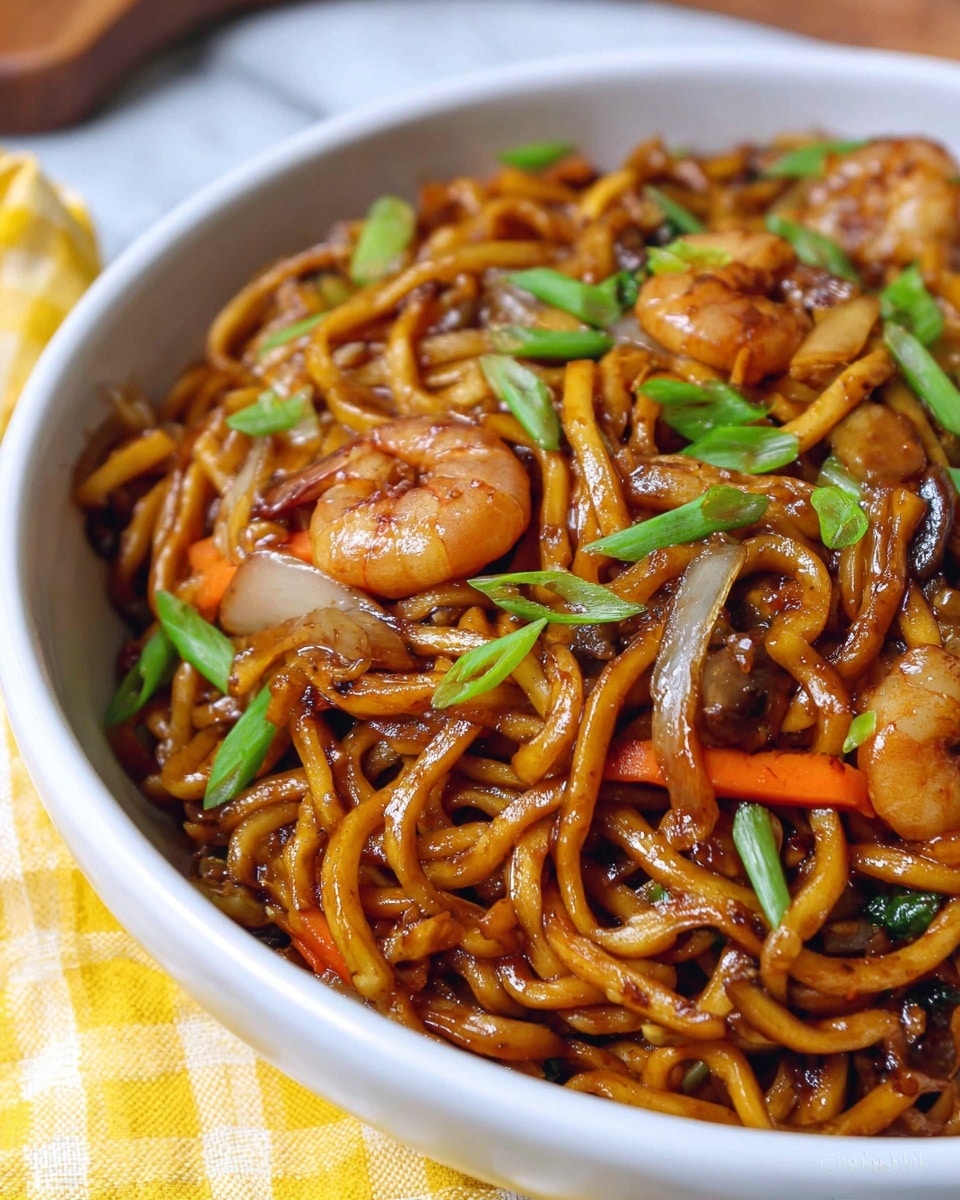 This image shows a bowl filled with thick, shiny, brown stir-fried noodles as the main layer, mixed with pieces of light brown mushrooms and small, pink shrimp on top. Bright green sliced spring onions are scattered over the noodles, adding color and texture. Thin slices of orange carrot and translucent white onion layers peek through the noodles, creating a mix of textures and colors. The bowl is white, placed on a white marbled surface with a yellow and white checkered cloth nearby, and the photo has a close-up, warm feel. Photo taken with an iphone --ar 4:5 --v 7