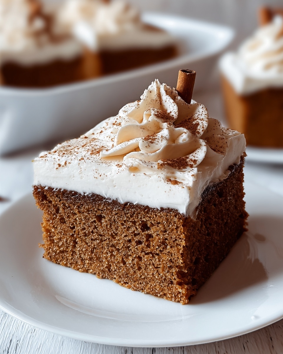 The image shows a close-up of a single slice of moist, brown cake with a fine crumb texture. It has one thick bottom layer of cake topped with a thick white frosting layer, smooth and slightly wavy. On top of the frosting, there is a swirl of whipped cream, off-white in color, sprinkled with fine brown powder and decorated with a small cinnamon stick. The slice sits on a plain white plate placed on a white marbled surface, with more slices of the same cake blurred in the background on a white dish. Photo taken with an iphone --ar 4:5 --v 7