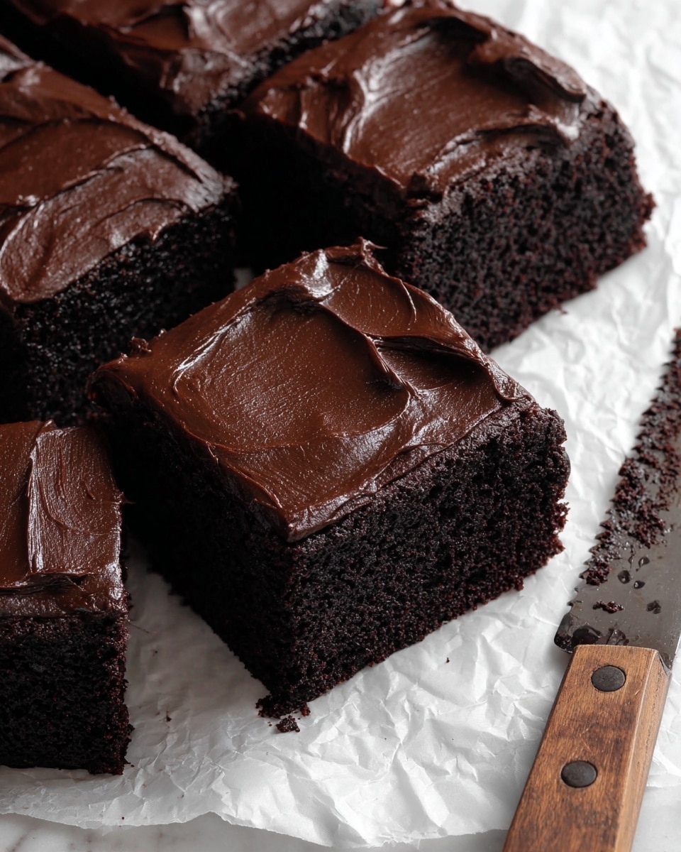This image shows four thick squares of dark chocolate cake with a rich, smooth layer of dark chocolate frosting on top. Each cake piece has one even, thick layer of moist, dense cake at the bottom with a thick, glossy, spread frosting layer sitting neatly above it. The frosting has slight swirls and a shiny texture. The pieces are placed closely together on crinkled white parchment paper over a white marbled surface. To the side, there is a serrated knife with a wooden handle resting with some chocolate crumbs on its blade. photo taken with an iphone --ar 4:5 --v 7
