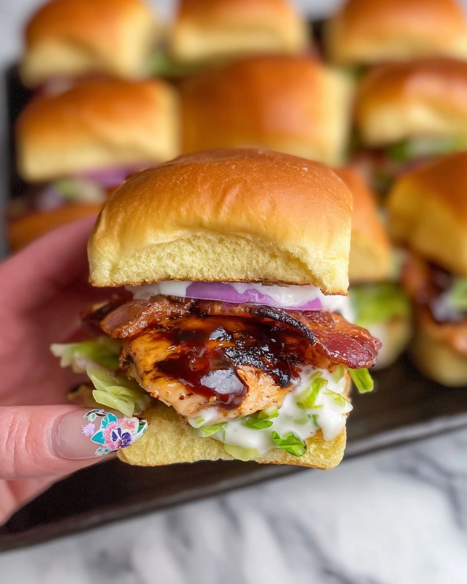 A close-up of a slider sandwich held by a woman's hand with colorful nail art, showing soft, slightly toasted golden brown bun on top and bottom. Inside the sandwich, there is a layer of light green shredded lettuce at the bottom, topped with a thick, juicy, grilled chicken breast with dark grill marks and a glazed barbecue sauce. Above the chicken, crispy brown bacon slices are placed, followed by thin rings of purple onion and bright green lettuce, all lightly dressed with a creamy white sauce. In the background, more sliders with the same layers are visible, all placed on a black tray on a white marbled surface. photo taken with an iphone --ar 4:5 --v 7