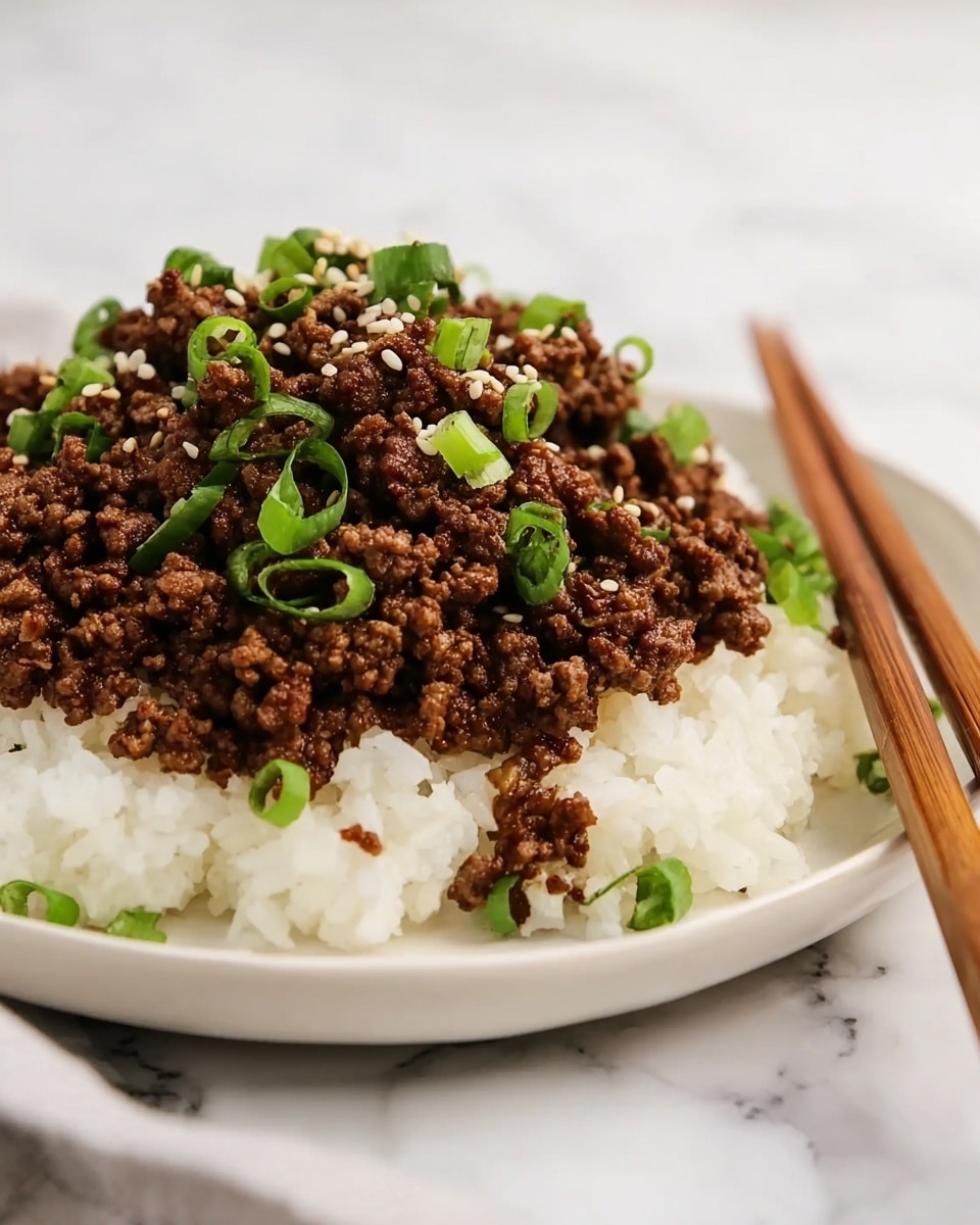 A white plate holds a layer of soft white rice as the base. On top of the rice is a thick layer of cooked ground beef, browned and crumbly. The beef is sprinkled with chopped bright green onions and white sesame seeds scattered across the top. A pair of wooden chopsticks rests beside the pile of beef on the plate. The background features a white marbled texture. Photo taken with an iphone --ar 4:5 --v 7